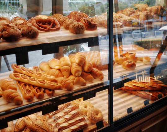 Afbeelding van een vitrine in een bakkerij met daarin verse broodjes