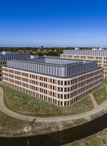 Afbeelding van het Amphia ziekenhuis in Breda vanuit de lucht genomen met een felblauwe lucht op de achtergrond.