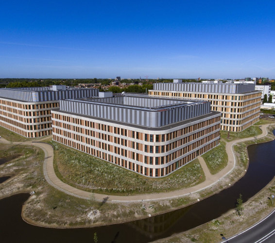 Afbeelding van het Amphia ziekenhuis in Breda vanuit de lucht genomen met een felblauwe lucht op de achtergrond.